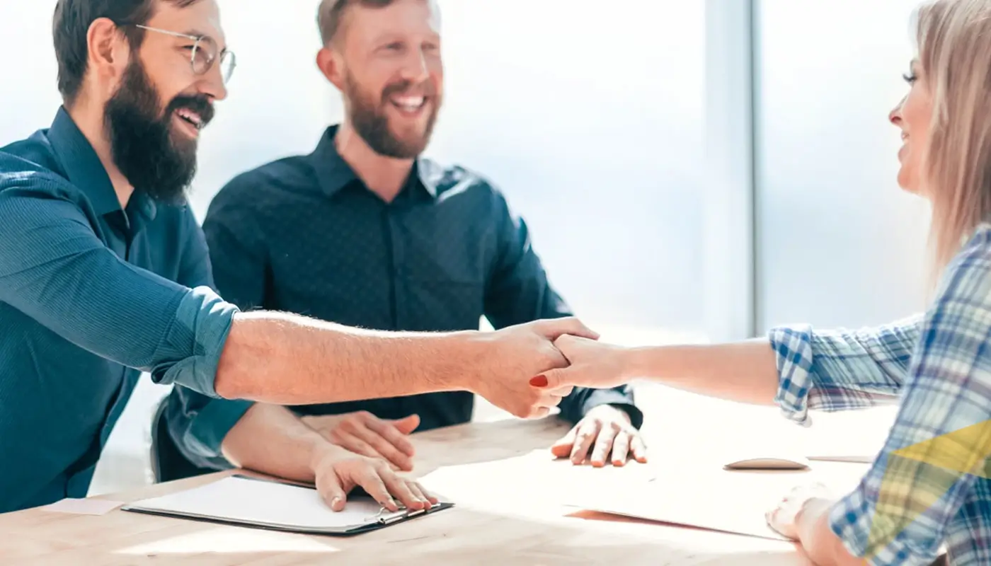 Mitarbeiter schütteln neuer Kollegin die Hand